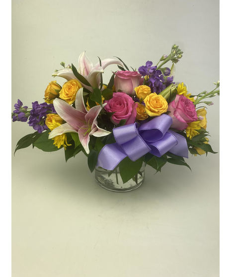 Floral centerpiece surrounding a pink taper candle.