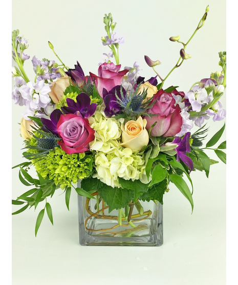 Pink and purple flowers in a clear glass vase.